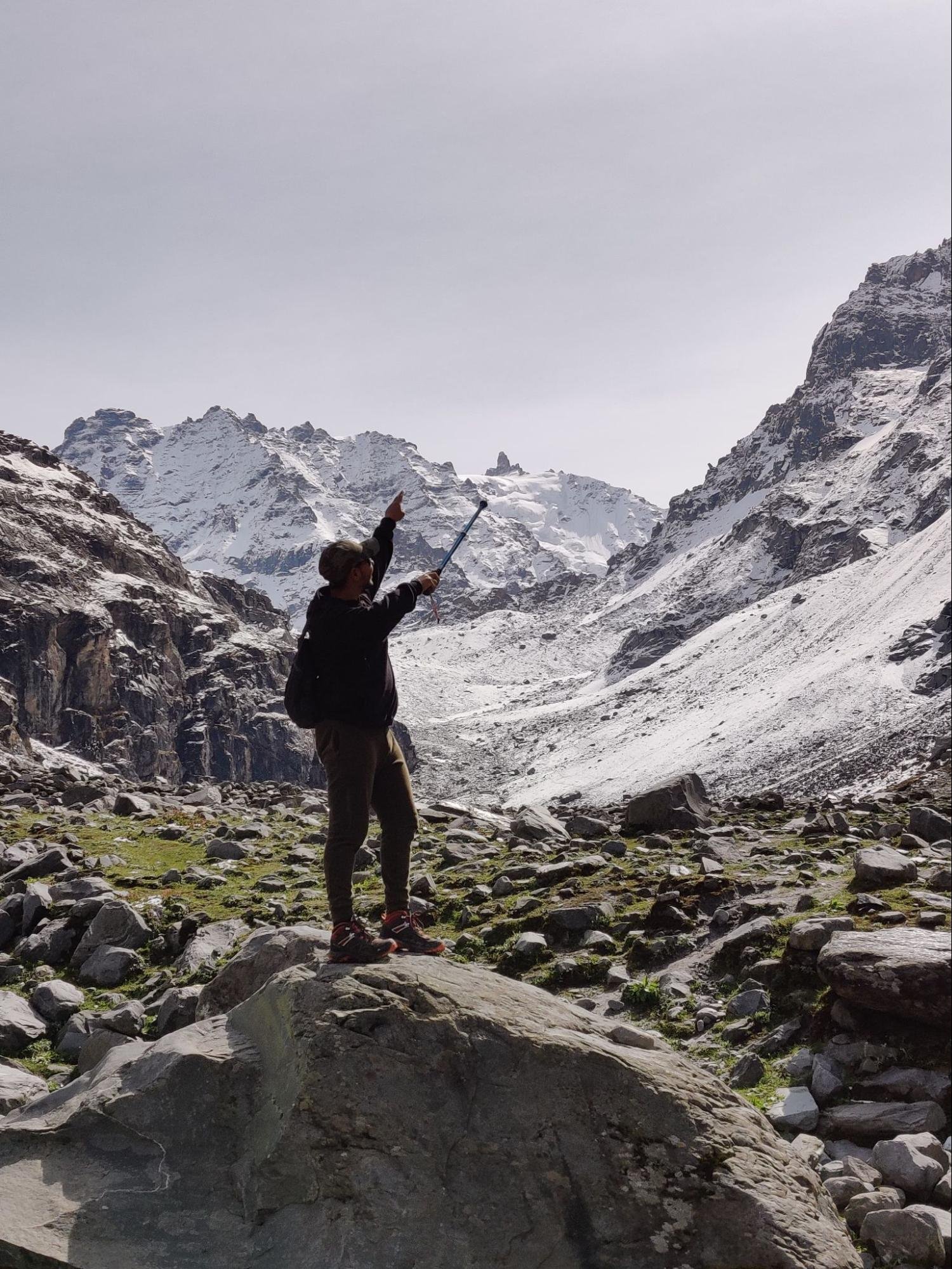 Trekker enjoying the view of snowy mountains at hampta pass