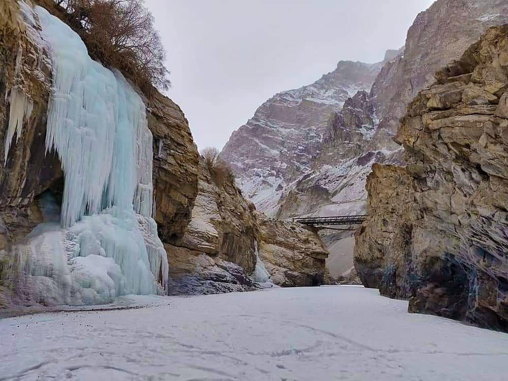 Frozen waterfall and icy river trail in a rocky mountain of leh ladakh