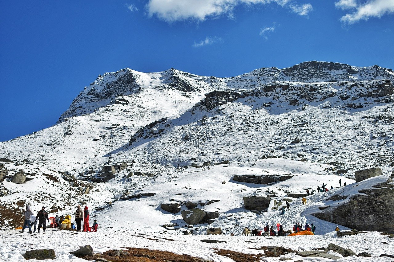 Tourists enjoying snow on a mountain slope in Manali.