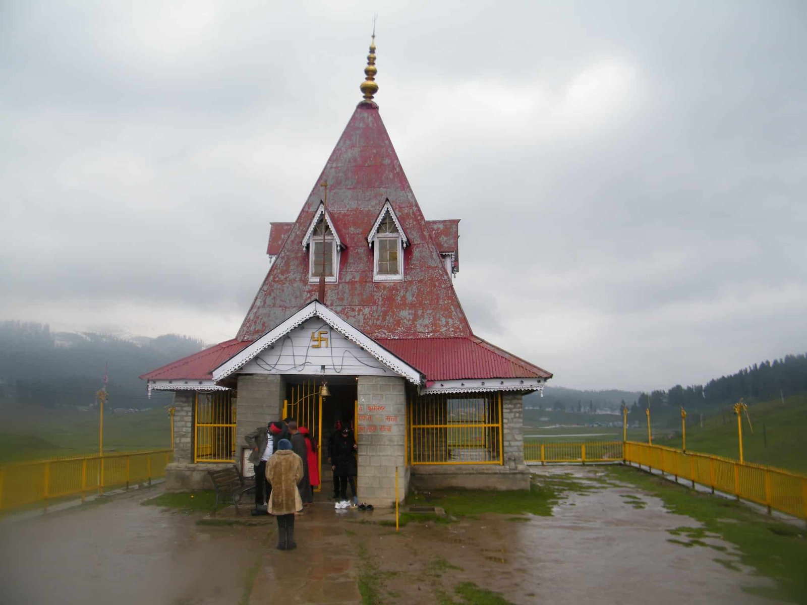 Maharani Temple in Gulmarg, Kashmir, with visitors at the entrance on a cloudy day