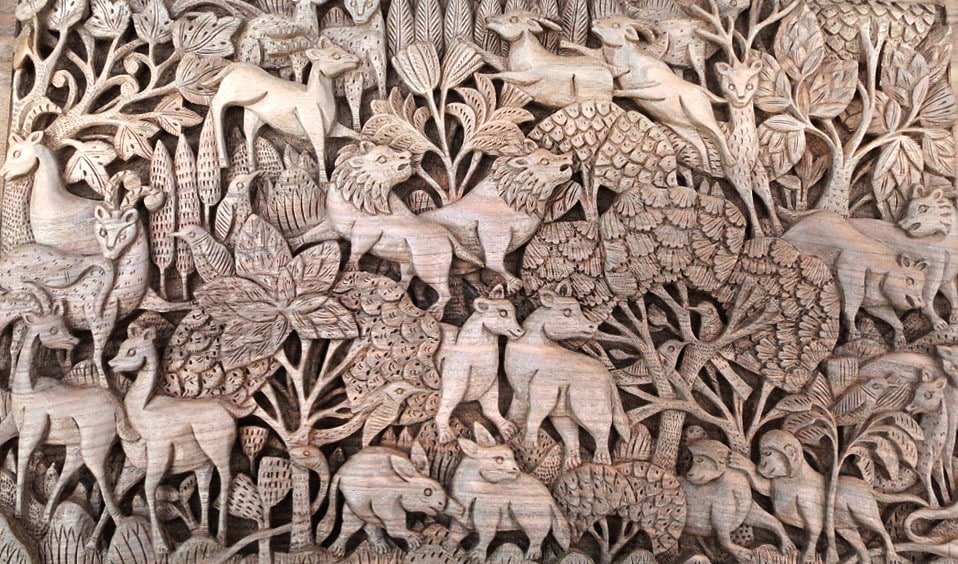 Intricately carved wooden panel with animals and trees.