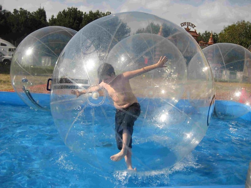 Boy zorbing inside a transparent inflatable ball on water in manali