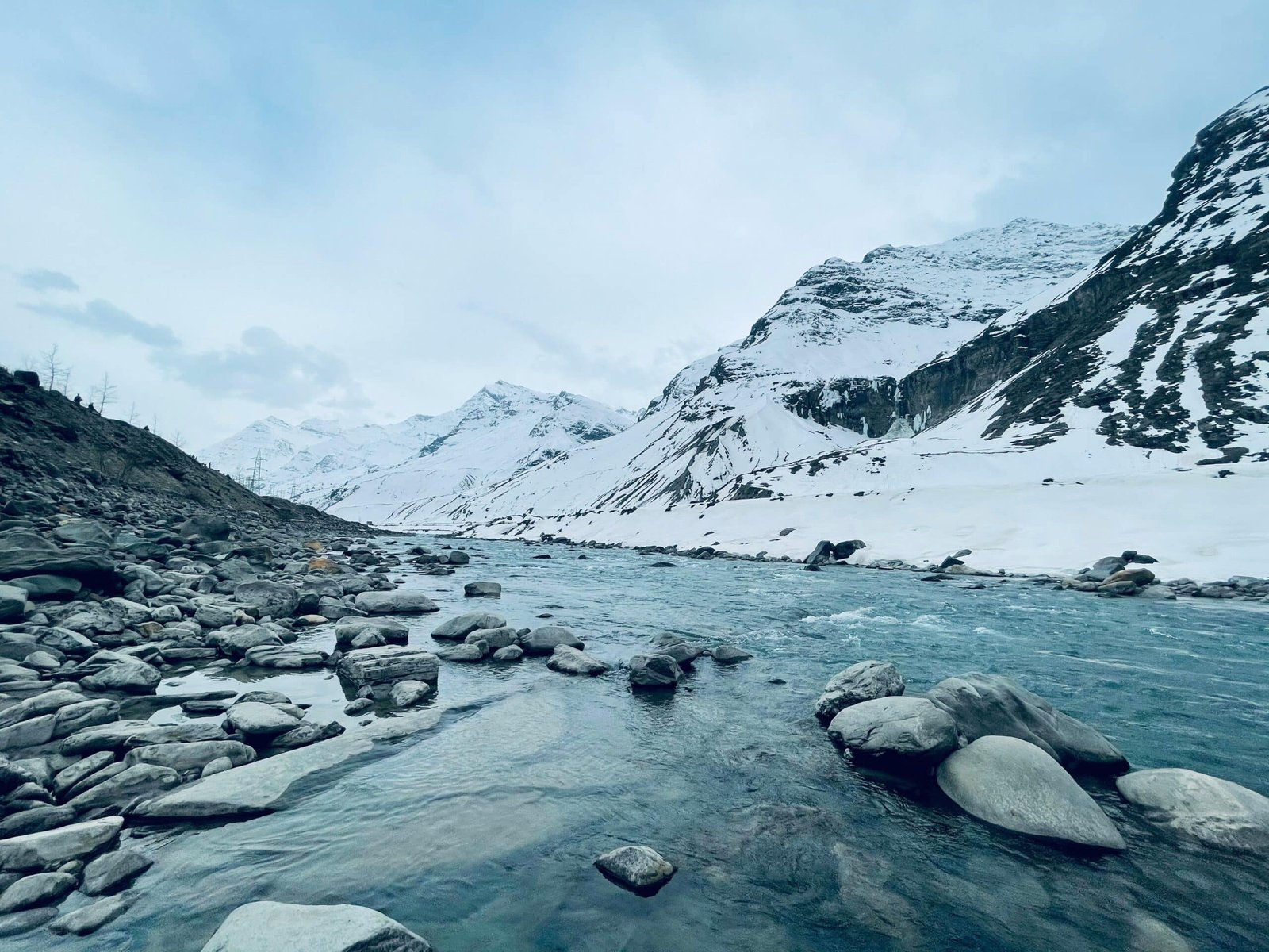 Snow-covered mountains and river at Sissu Lake, Himachal Pradesh.