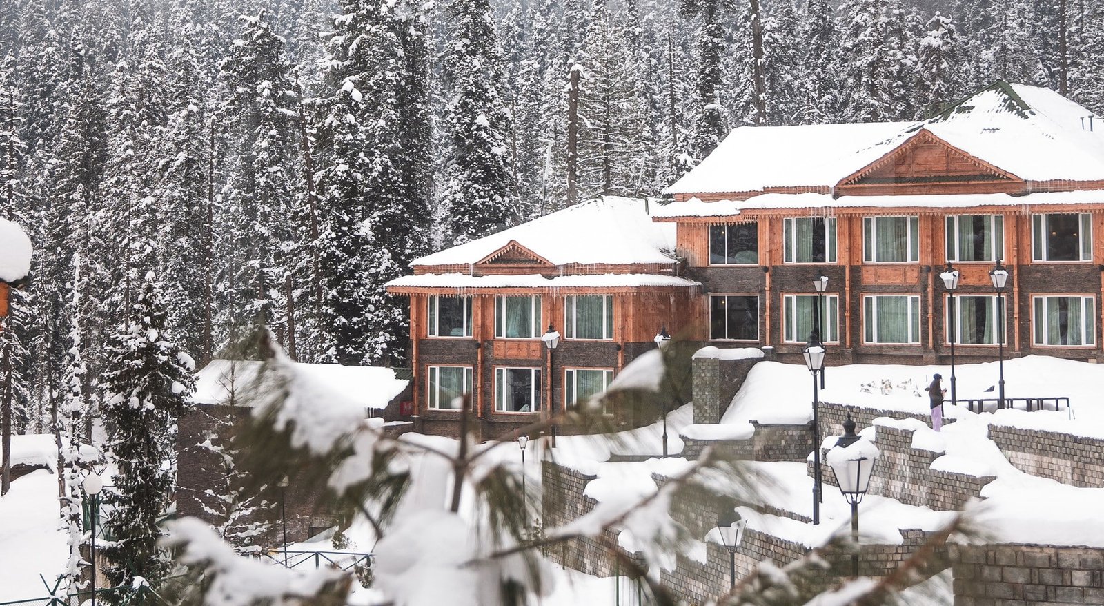 Snow-covered hotel surrounded by pine trees