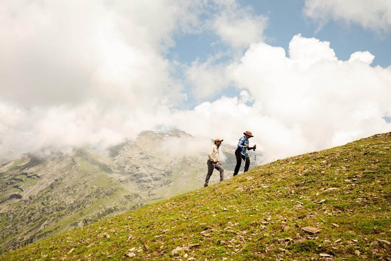 two trekkers are climbing mountain with help of equipments in Nafran Valley Trek