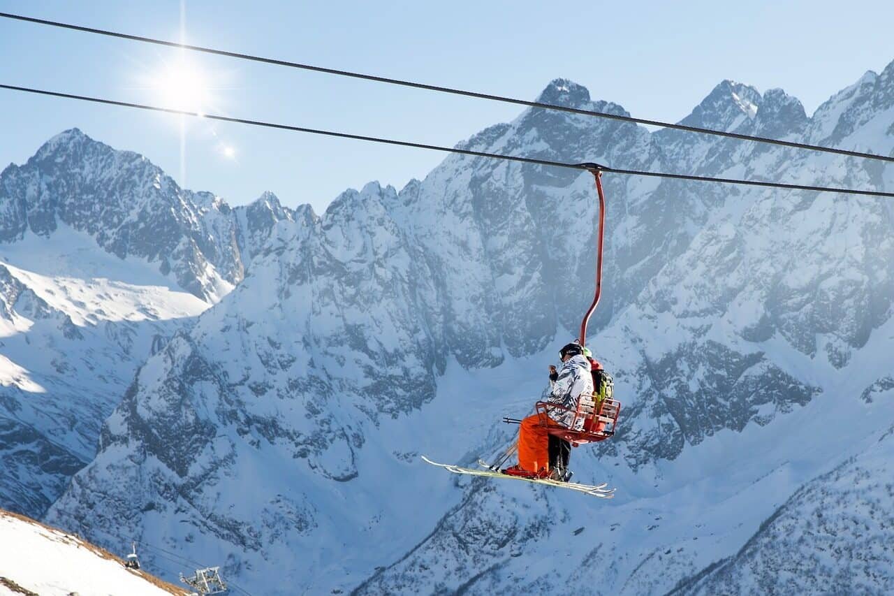 Skiers on chairlift in snowy mountains