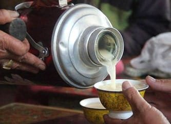 Butter tea being poured into a traditional cup