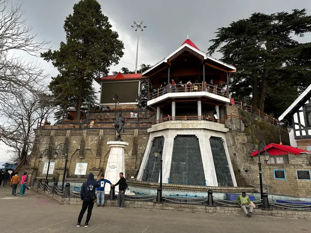 Hawa Ghar in Shimla with tourists and a statue in front