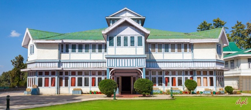 Shimla State Museum building with green roof and white walls, set against a clear blue sky