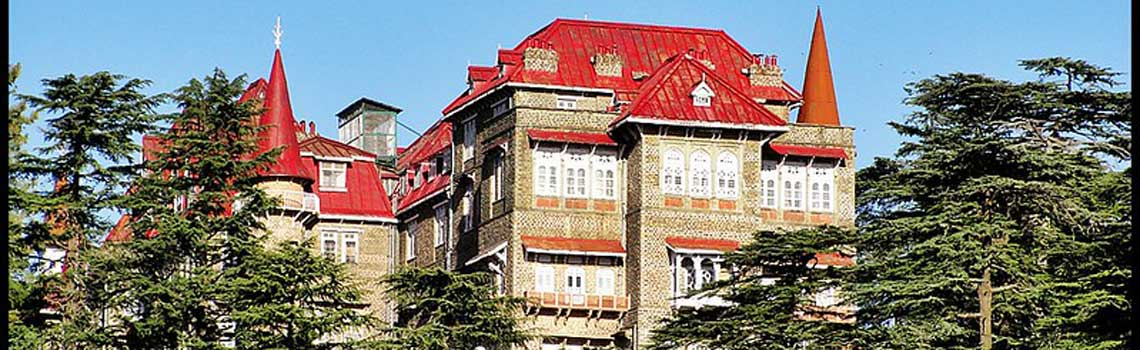 Gorton Castle in Shimla with red roofs and surrounded by trees