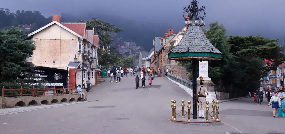 People walking near Scandal Point in Shimla with historic buildings and a police post in the center