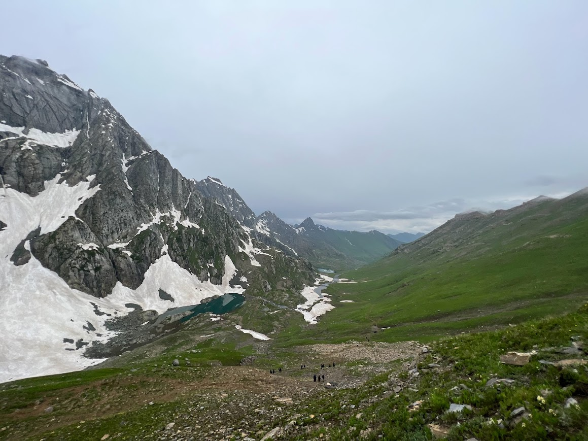 Lush green valley with snow patches on Kashmir Great Lakes Trek in August