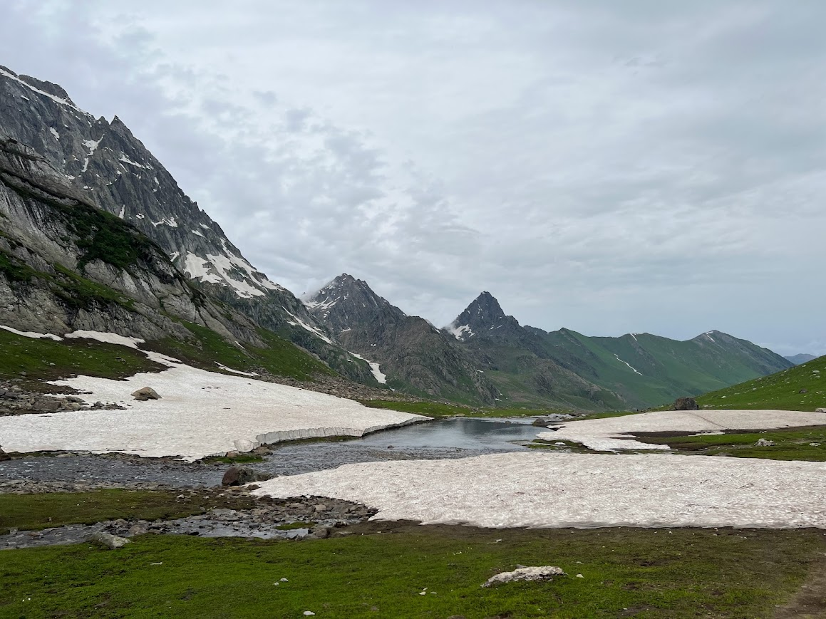 Snow patches and green meadows on Kashmir Great Lakes Trek in July